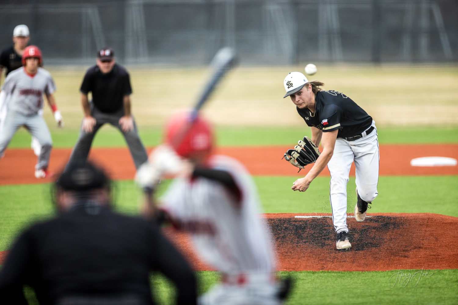 Baseball pitcher throwing a fastball to a batter.