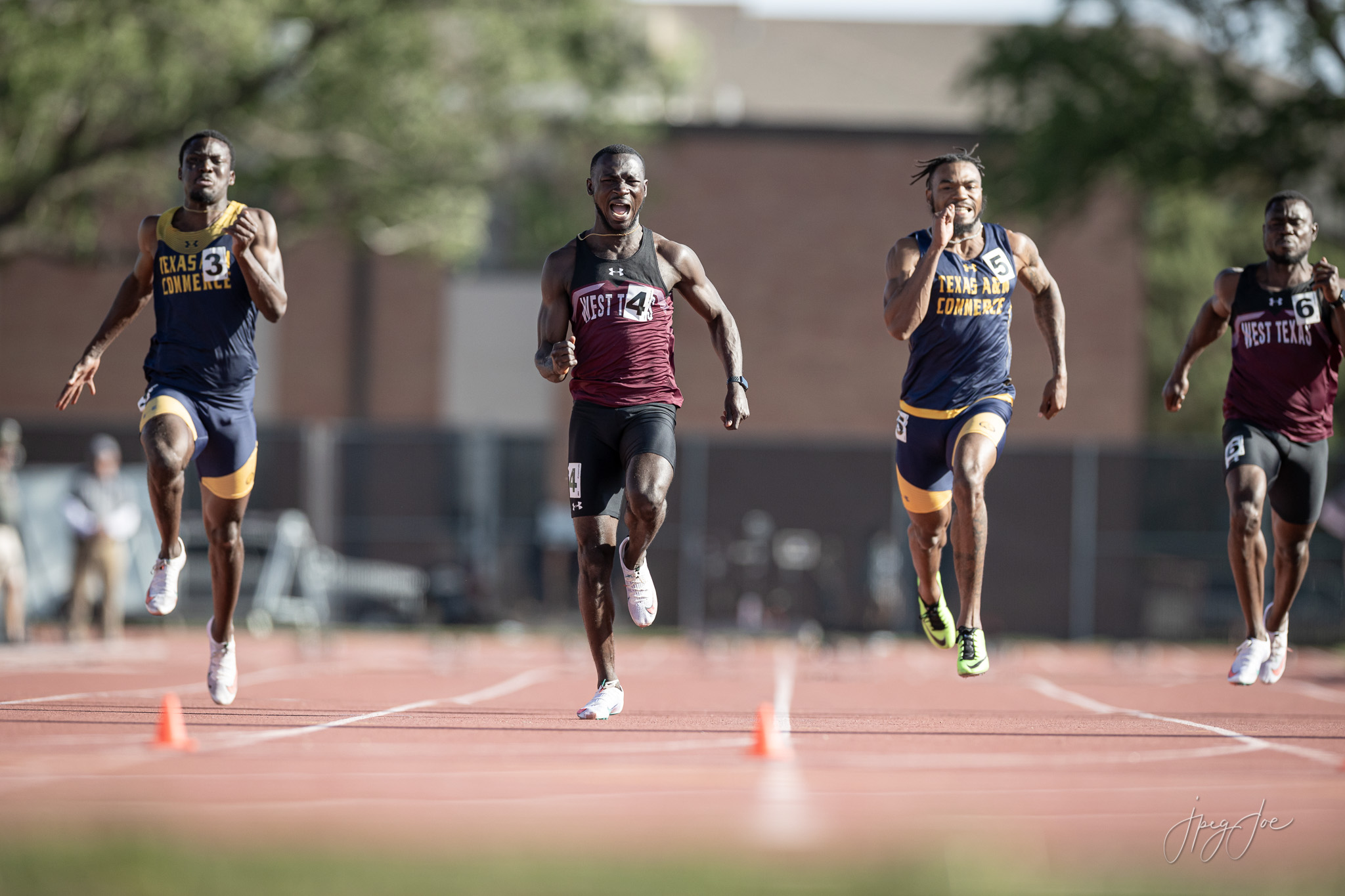 A group of male athletes run down the track at the 2021 Lone Star Conference Track meet.